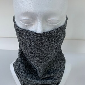 May include: Gray and black patterned neck gaiter, worn on a white mannequin head.