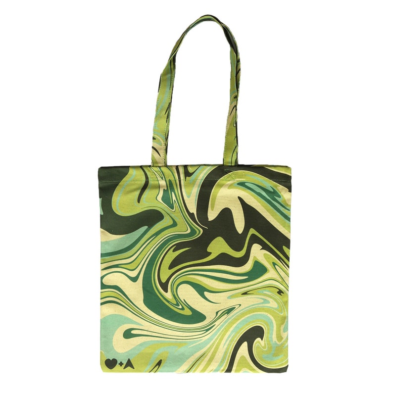 May include: A green tote bag with a swirling, marbled pattern in shades of green, black, and cream. The bag has matching handles and a rectangular shape. The design includes a heart symbol, the letter A, and a plus sign.