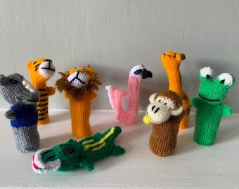 May include: A set of eight knitted finger puppets featuring various animals, including a tiger, lion, flamingo, giraffe, monkey, frog, and a crocodile. The puppets are made with colorful yarn and have detailed facial features.