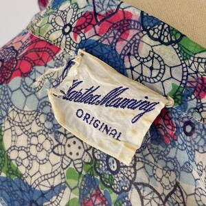 Close of of the label of the 1940's shirtwaist dress. The label reads "Martha Manning ORIGINAL" in blue script.