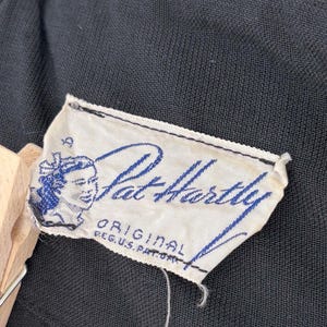 Close-up of the interior showing the label. The label features the name "Pat Hartley" in blue script, along with an illustration of a woman's face and the text "ORIGINAL REG. U.S. PAT. OFF."