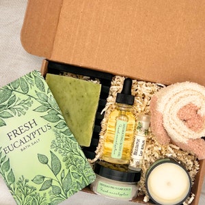 a box with a candle, soap, soap bar, and other items in it