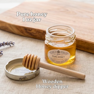 a jar of pure honey and a wooden honey dipper on a wooden surface.