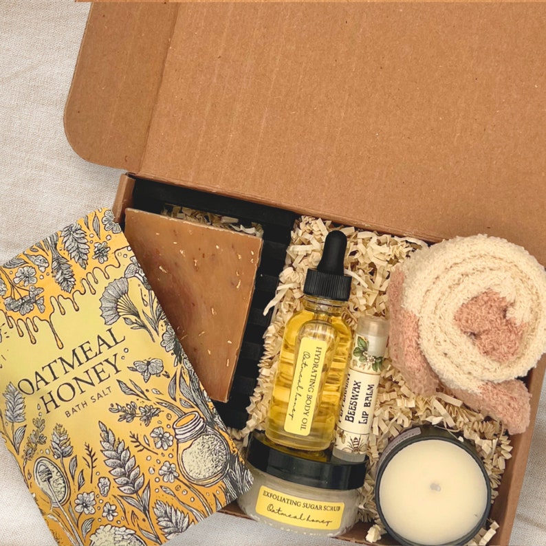 an open box containing a candle, soap, and other items