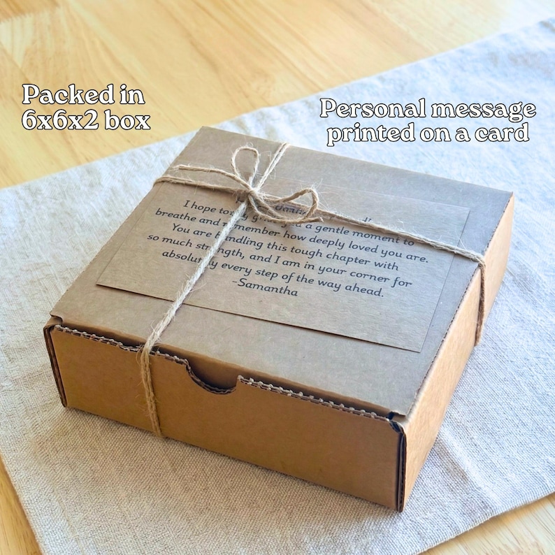 A cardboard box with a personal message printed on a card tied with twine, placed on a wooden surface.