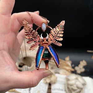Chimera vial necklace with glittery green water, Copper eformed real beetle elytras with ferns wings, a rainbow moonstone and a white moon
