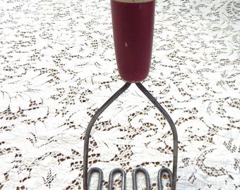 Machacador de patatas antiguo con mango de madera roja y blanca