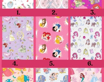Può includere: Una griglia di nove motivi in tessuto raffiguranti varie principesse animate, tra cui Biancaneve, Cenerentola, Ariel, Belle, Jasmine e Raperonzolo, visualizzate in diverse tavolozze di colori come rosa, bianco, viola e giallo con motivi floreali.