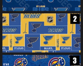 Pode incluir: Três padrões de tecido com a marca NHL dos St. Louis Blues. O padrão 1 tem logótipos azuis num fundo azul escuro. O padrão 2 é uma grelha amarela e azul com logótipos e tacos de hóquei. O padrão 3 apresenta trompetes e logótipos circulares.