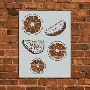 May include: A stencil with five different citrus fruit designs. The stencil includes a whole orange, a half orange, a lemon wedge, and two orange slices.