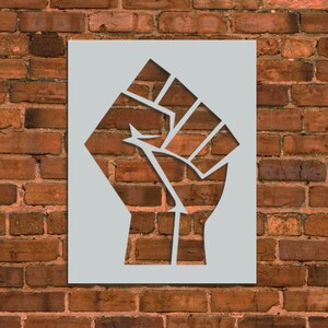 May include: A stencil of a raised fist, a symbol of protest and solidarity. The stencil is made of a thin, white material and is designed to be used with spray paint.