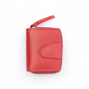 May include: A bright red leather wallet featuring a smooth finish, a secure wrap-around zipper closure with a matching red leather pull tab, and a front flap with a snap button closure, all accented with visible tonal stitching throughout the design.