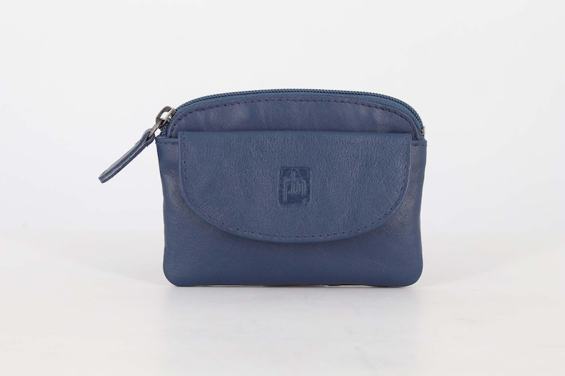 May include: A navy blue leather coin purse featuring a top zipper closure and a front flap pocket with a snap button. The front flap is embossed with a small square logo containing the letters ph. The purse has a smooth texture and rounded corners.