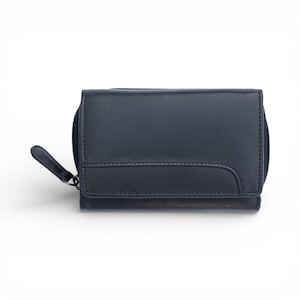 May include: A dark navy blue leather wallet featuring a rectangular flap with a curved stitched seam detail. The wallet includes a side zip closure with a matching leather pull tab, providing a secure and compact design for everyday storage.