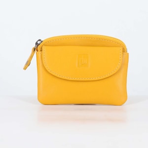 May include: A bright yellow coin purse with a smooth finish, featuring a top zipper closure and a front flap pocket with a small embossed square logo. The rectangular pouch has rounded corners and a matching yellow leather zipper pull tab.