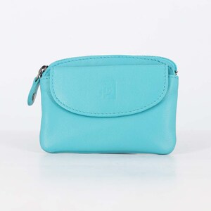 May include: A bright turquoise leather coin purse featuring a top zipper closure and a front flap pocket with a small embossed square logo. The compact accessory has a smooth texture and rounded edges, providing a simple design for carrying small items.