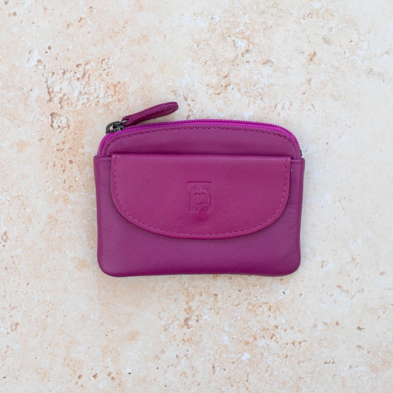 a fuchsia leather coin purse with a zippered section which has a zipper puller and a front pocket.