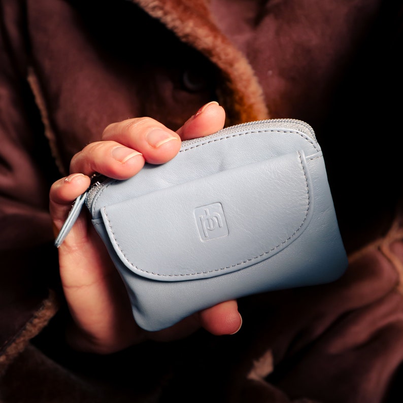 a lady holding blue grey coin purse