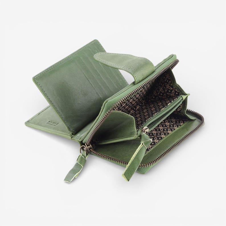 May include: Open green leather wallet with multiple compartments, including card slots and a zipped coin pouch. The wallet features a textured exterior and a patterned interior lining. The zip pulls are made of matching green leather.
