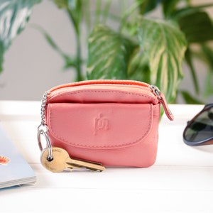 a coral-pink leather coin purse with a keyring chain
