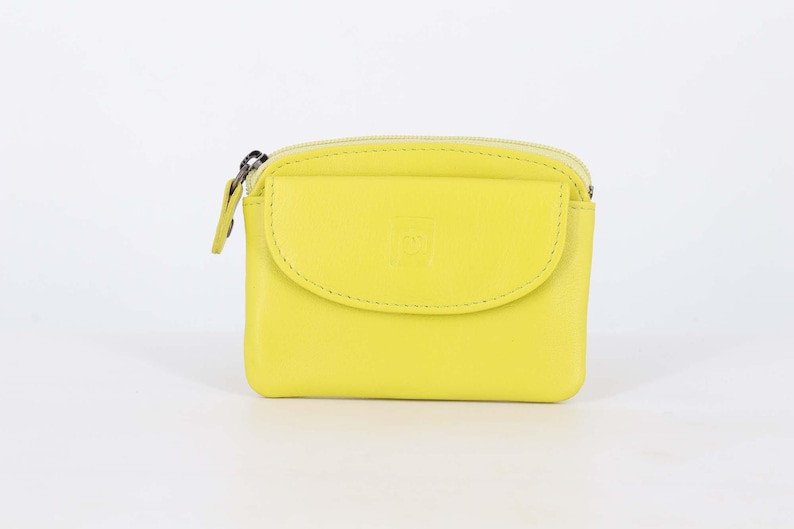 May include: A bright lime yellow coin purse featuring a smooth exterior, a top zipper closure with a matching pull tab, and a front flap pocket with a subtle embossed logo detail. The rectangular pouch has rounded corners and a compact design.