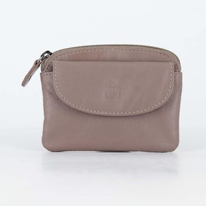 May include: A taupe leather coin purse featuring a top zipper closure and a front flap pocket with a snap button. The small rectangular pouch has a smooth texture and a metal zipper pull, providing a compact storage solution for small items.