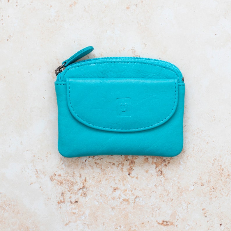 a blue leather coin purse with a zippered section which has a zipper puller and a front pocket.