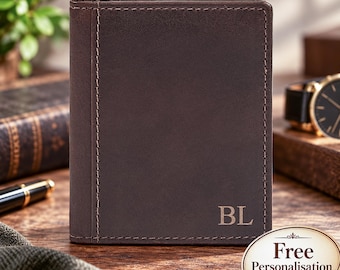 May include: A dark brown leather wallet featuring vertical stitching along the left side and the embossed initials BL in the bottom right corner. The wallet has a smooth, matte finish and a rectangular shape with clean, straight edges.