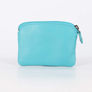 May include: A small, rectangular turquoise coin purse featuring a smooth leather-like texture and a matching turquoise zipper closure along the top edge. The pouch has rounded corners and a simple, clean design with a silver-toned metal zipper pull.