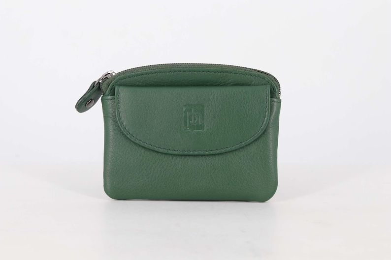 May include: A forest green leather coin purse featuring a top zipper closure and a front flap pocket with a snap button. The front flap is embossed with a small square logo containing the letters 'ph'. The purse has a smooth, rounded rectangular shape.