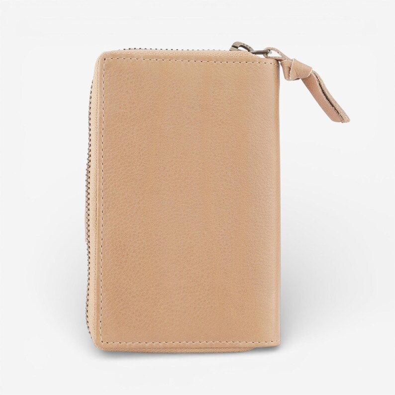 May include: A rectangular, tan leather wallet with a zip closure and a small leather pull tab. The wallet has a textured surface and a minimalist design, suitable for carrying cards and cash.
