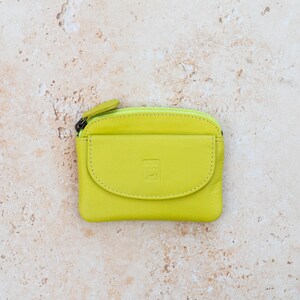 a lime green leather coin purse with a zippered section which has a zipper puller and a front pocket.