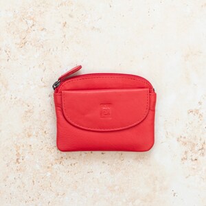 a red leather coin purse with a zippered section which has a zipper puller and a front pocket.