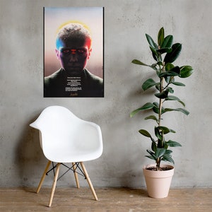 Puede incluir: Un p&oacute;ster de pel&iacute;cula para la pel&iacute;cula "Stranger Things" con una persona joven con una luz roja y azul reflej&aacute;ndose en su rostro. El p&oacute;ster est&aacute; en un marco negro y est&aacute; colgado en una pared gris.
