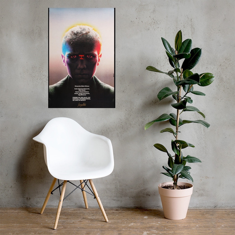 Puede incluir: Un p&oacute;ster de pel&iacute;cula para la pel&iacute;cula "Stranger Things" con una persona joven con una luz roja y azul reflej&aacute;ndose en su rostro. El p&oacute;ster est&aacute; en un marco negro y est&aacute; colgado en una pared gris.