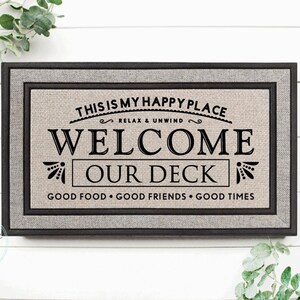 May include: A welcome mat with the text "This is my happy place Relax & Unwind Welcome Our Deck Good Food Good Friends Good Times" printed on it.
