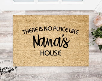 May include: A tan coir doormat with the text "There is no place like Nana's House" in black lettering.