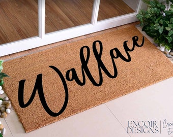 May include: A brown coir doormat with the name "Wallace" written in black cursive script.
