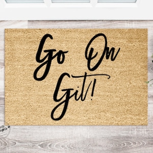 May include: A brown coir doormat with the text "Go On Git!" in black cursive lettering.