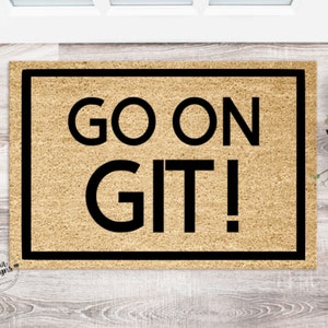May include: A brown doormat with black trim and the text "GO ON GIT!" in black lettering.