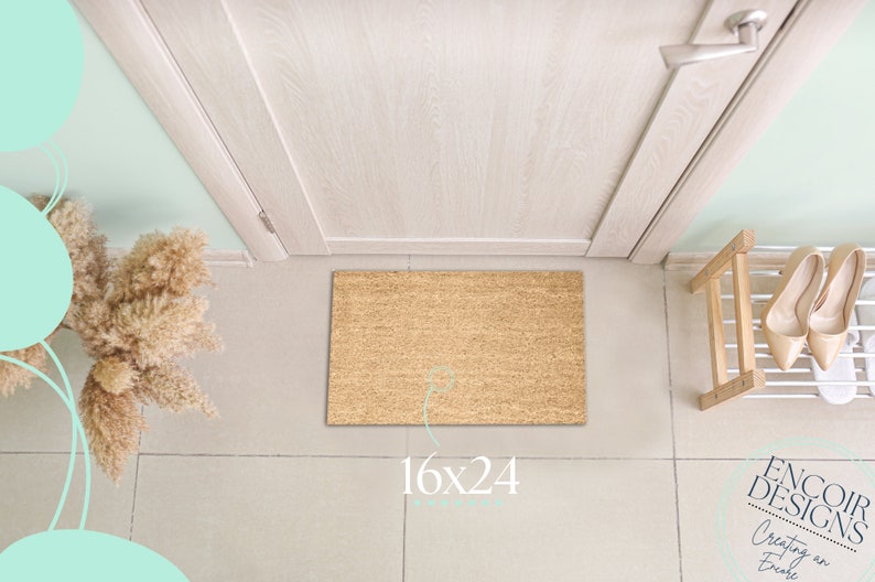 May include: A brown coir doormat with the text "16x24" printed on it. The doormat is placed in front of a white door with a silver door handle. The doormat is in a hallway with light beige tiled flooring.