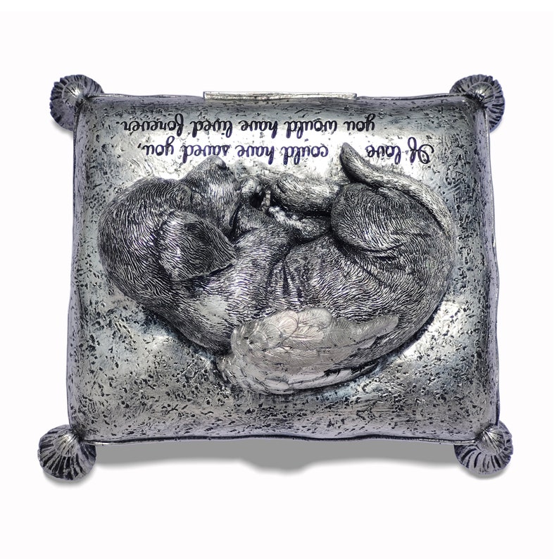 May include: Silver metal keepsake box with a sculpted image of a dog with wings sleeping on a pillow. The box has an inscription that reads "If love could have saved you, you would have lived forever."