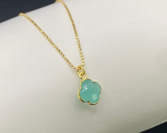 May include: A gold chain necklace with a light blue four-leaf clover pendant.
