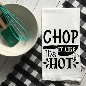 May include: White kitchen towel with black text that reads "Chop it like it's hot" with a knife graphic.