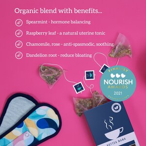 May include: A pink background with a blue and white box of tea bags. The box has the text "Hottea Mama" and a graphic of a teacup with steam. The tea bags are labeled with the text "Raspberry Leaf Treatment". The text "Organic blend with benefits..." is at the top of the image. The text "Finalist Nourish Awards 2021" is in a blue circle with three hearts. The text "Spearmint - hormone balancing", "Raspberry leaf - a natural uterine tonic", "Chamomile, rose - anti-spasmodic, soothing", and "Dandelion root - reduce bloating" is listed below the text "Organic blend with benefits..." with a green leaf icon next to each item.