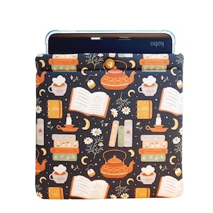 May include: A navy blue Kobo e-reader sleeve with a whimsical pattern of books, teapots, teacups, candles, and moons. The design includes the word "NOTES" on small orange notebooks. The sleeve is designed to hold an e-reader.