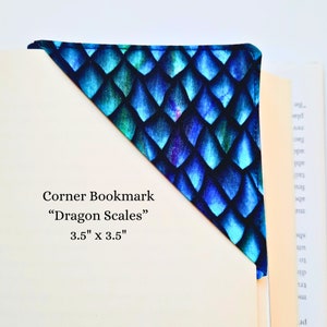 May include: A blue and green corner bookmark with a dragon scale pattern. The bookmark is 3.5 inches by 3.5 inches. The text "Corner Bookmark" "Dragon Scales" 3.5" x 3.5" is printed on the bookmark.