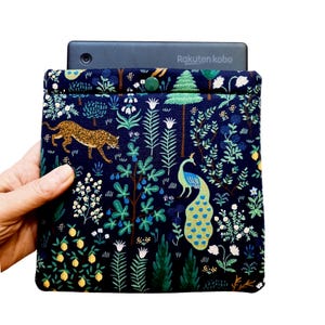 May include: A black and blue fabric e-reader case with a peacock and leopard print. The case has a button closure and the text "Rakuten kobo" is printed on the front.