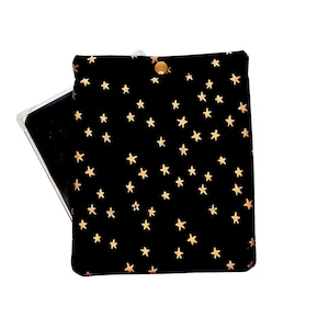 May include: Black phone case with a gold star pattern. The case is closed with a gold snap. The phone is visible inside the case. The case is designed to protect the phone.