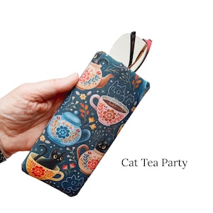 Pu&ograve; includere: Un astuccio per occhiali blu scuro con un design stravagante "Cat Tea Party". L'astuccio presenta teiere, tazze da t&egrave; e gatti neri. Il testo "Cat Tea Party" &egrave; stampato sul lato destro.